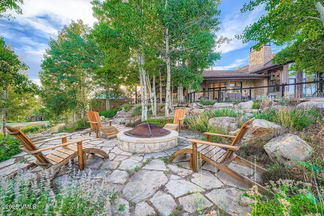 a view of a patio with a dining table and chairs under an umbrella with a fire pit