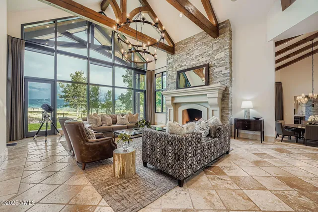 a living room with furniture a fireplace and a floor to ceiling window