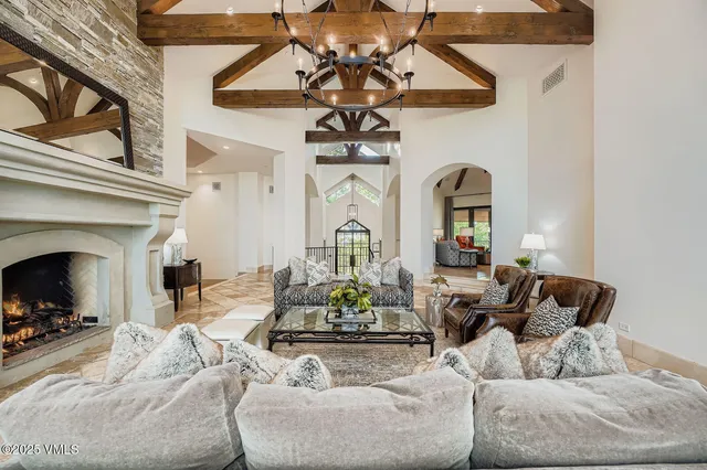 a living room with furniture a fireplace and chandelier