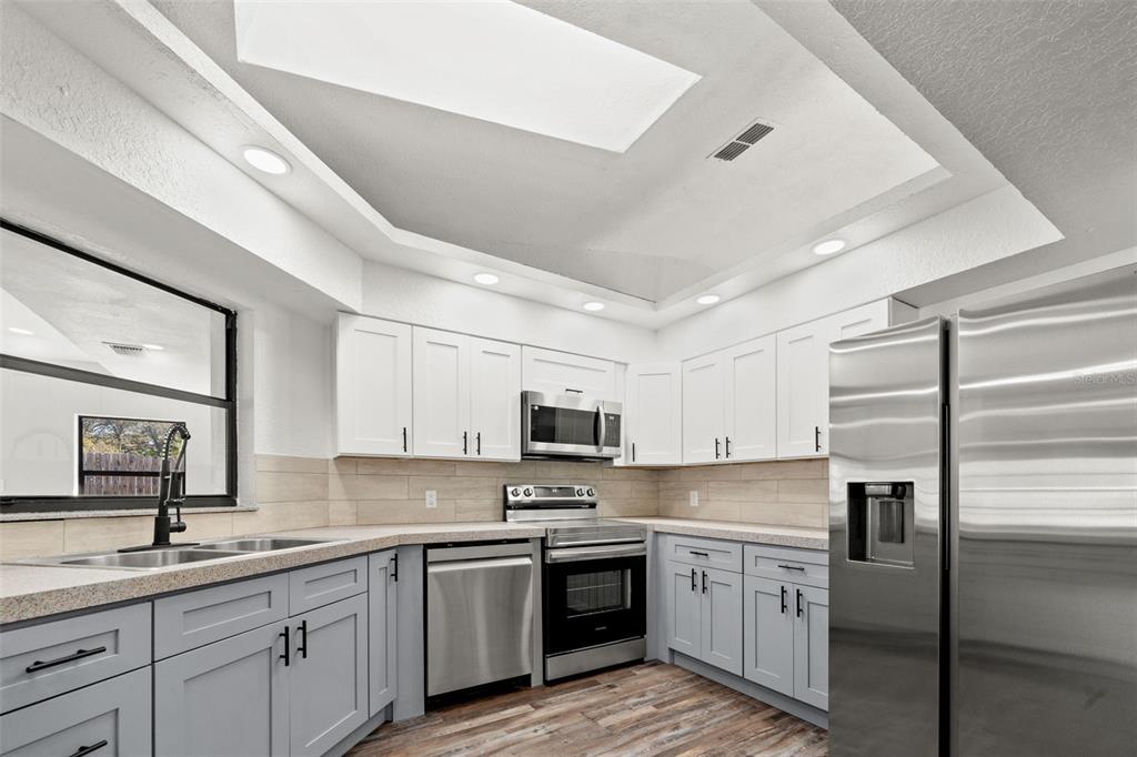 11215 Addison Street Spring Hill, FL 34609 - Photo 16 of 51 a kitchen with a sink stainless steel appliances and white cabinets