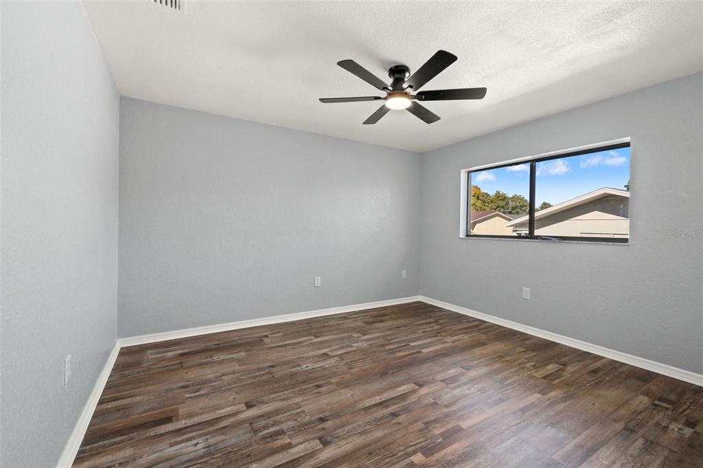 11215 Addison Street Spring Hill, FL 34609 - Photo 20 of 51 a view of a big room with wooden floor and windows