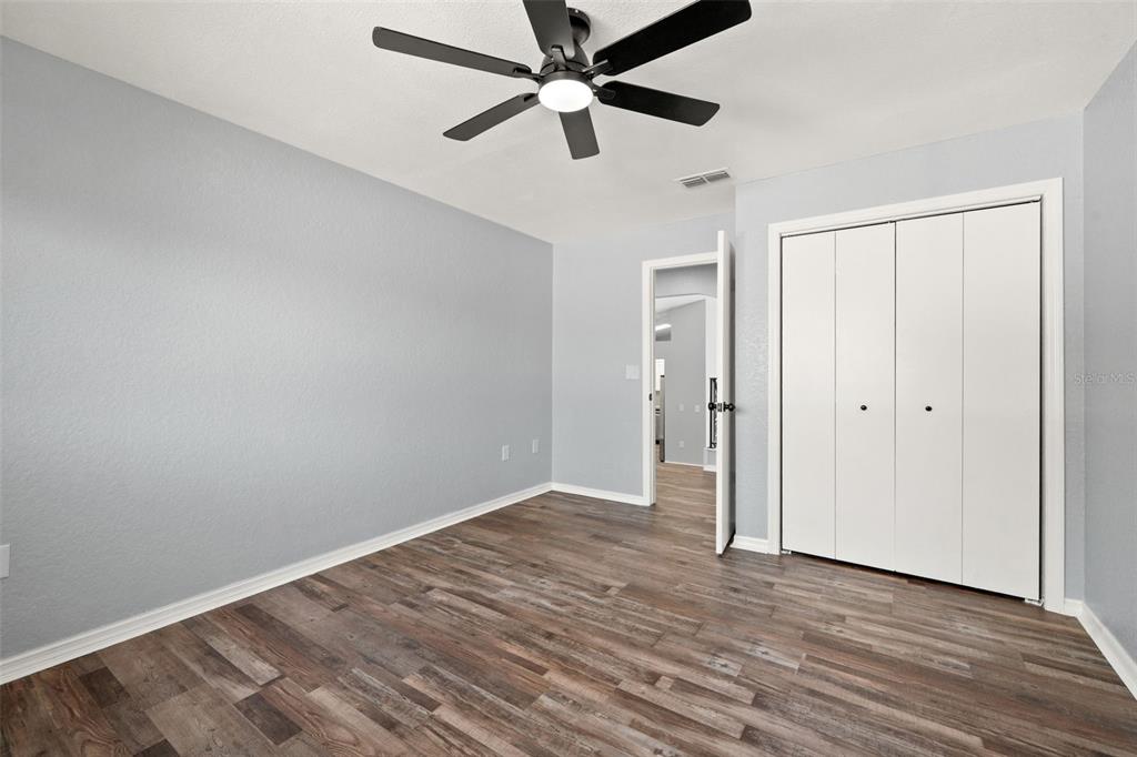 11215 Addison Street Spring Hill, FL 34609 - Photo 21 of 51 an empty room with wooden floor a ceiling fan and closet
