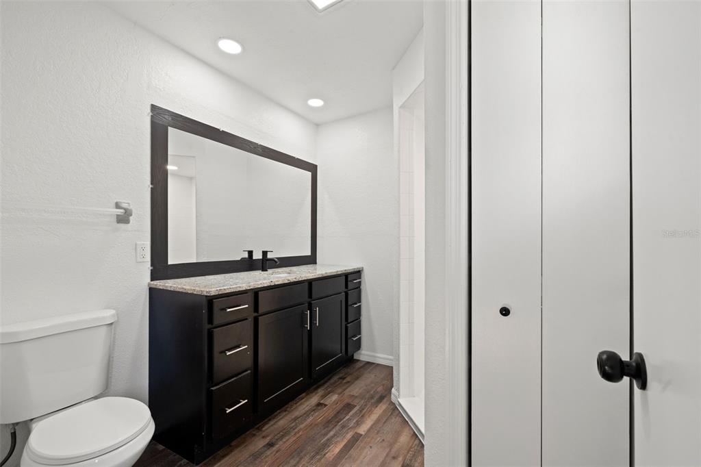 11215 Addison Street Spring Hill, FL 34609 - Photo 25 of 51 a bathroom with a toilet a sink and mirror