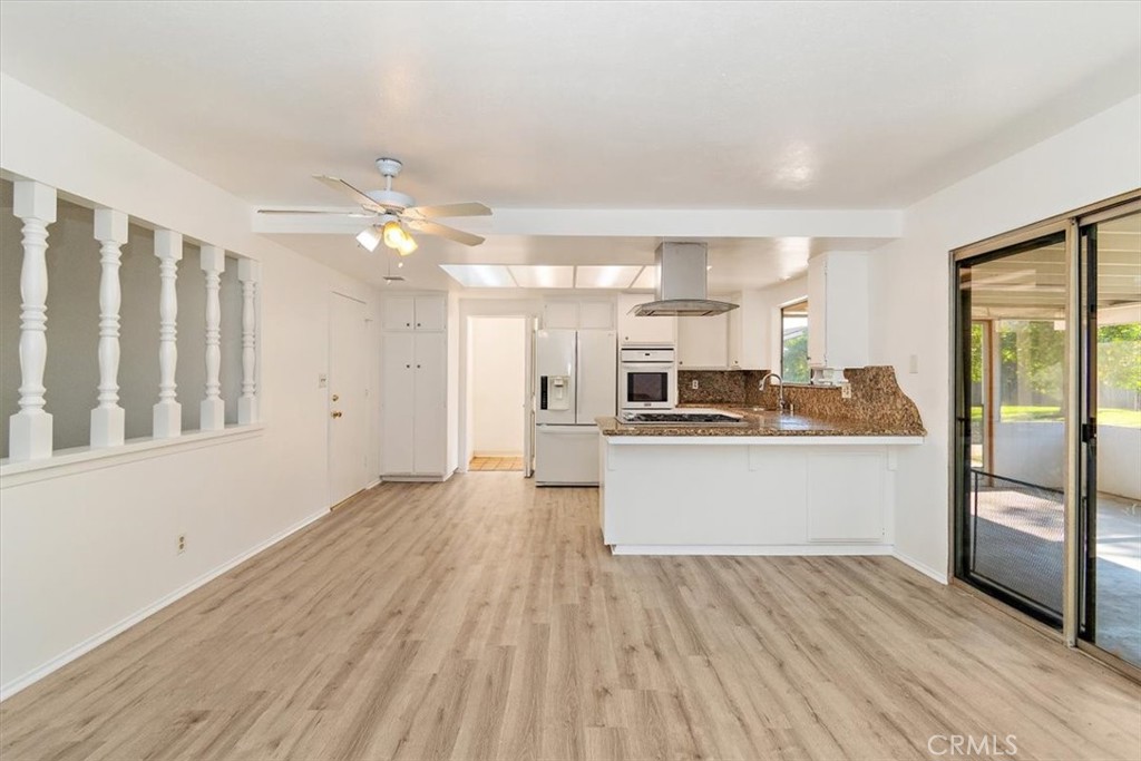 1330 La Serena Drive Glendora, CA 91740 - Photo 11 of 36 a kitchen with stainless steel appliances kitchen island wooden floors and white cabinets