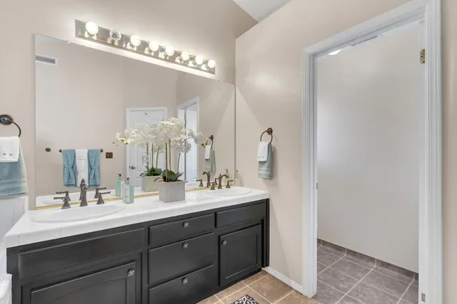 a bathroom with a double vanity sink and a mirror