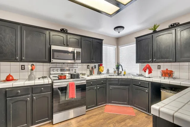 a kitchen with stainless steel appliances a sink dishwasher a stove and cabinets