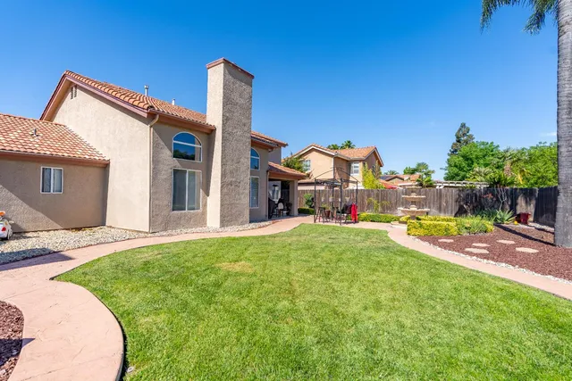 a view of a house with a backyard and a patio