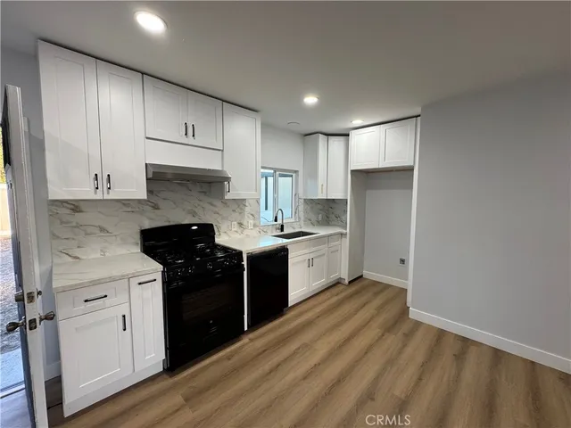 a kitchen with a sink a stove and cabinets