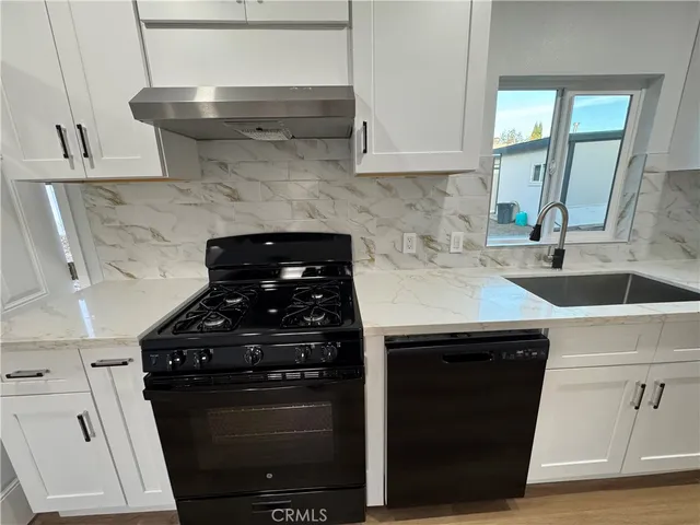 a kitchen with a sink a stove and cabinets