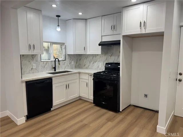a kitchen with a sink a stove and cabinets