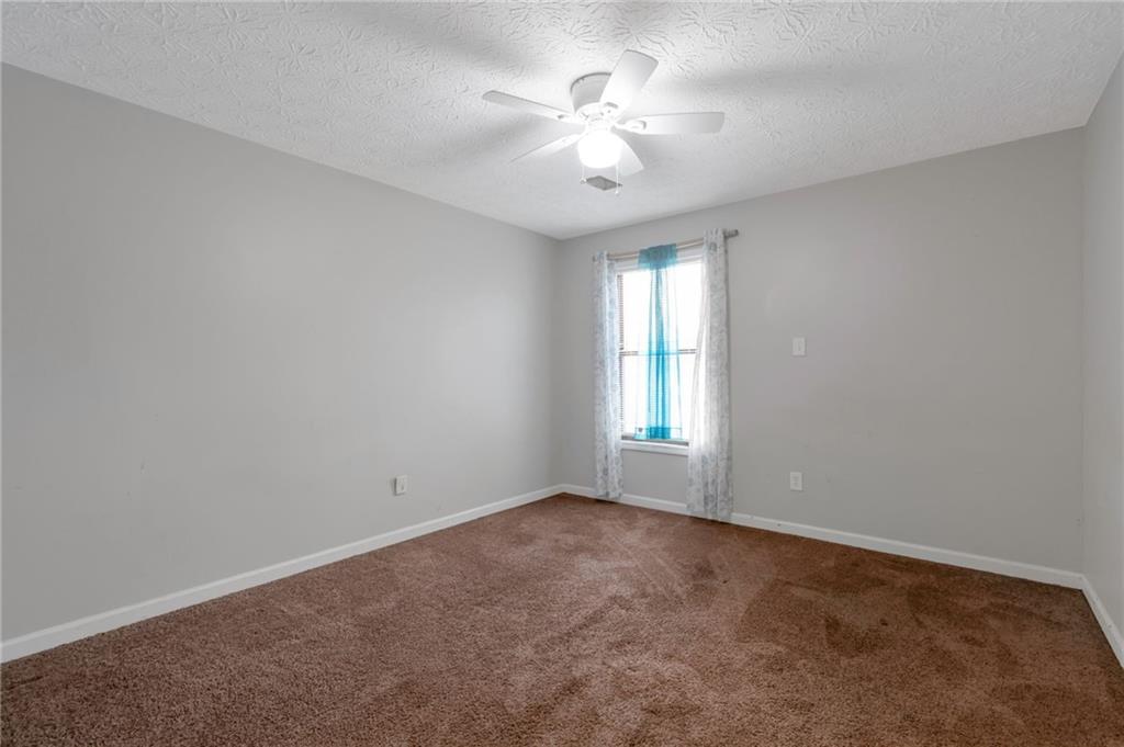 3523 Liberty Ridge Trail Marietta, GA 30062 - Photo 15 of 25 an empty room with windows and chandelier fan