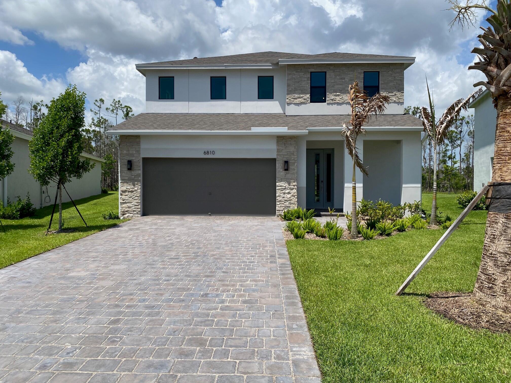 a front view of a house with a yard and garage