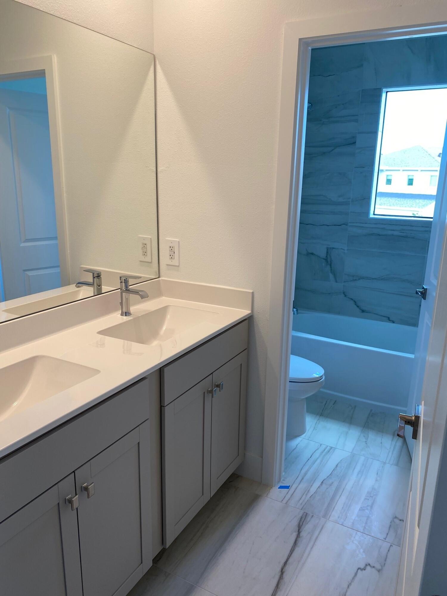 6810 Southeast Park Trace Drive Stuart, FL 34997 - Photo 19 of 21 a bathroom with a sink a toilet and shower