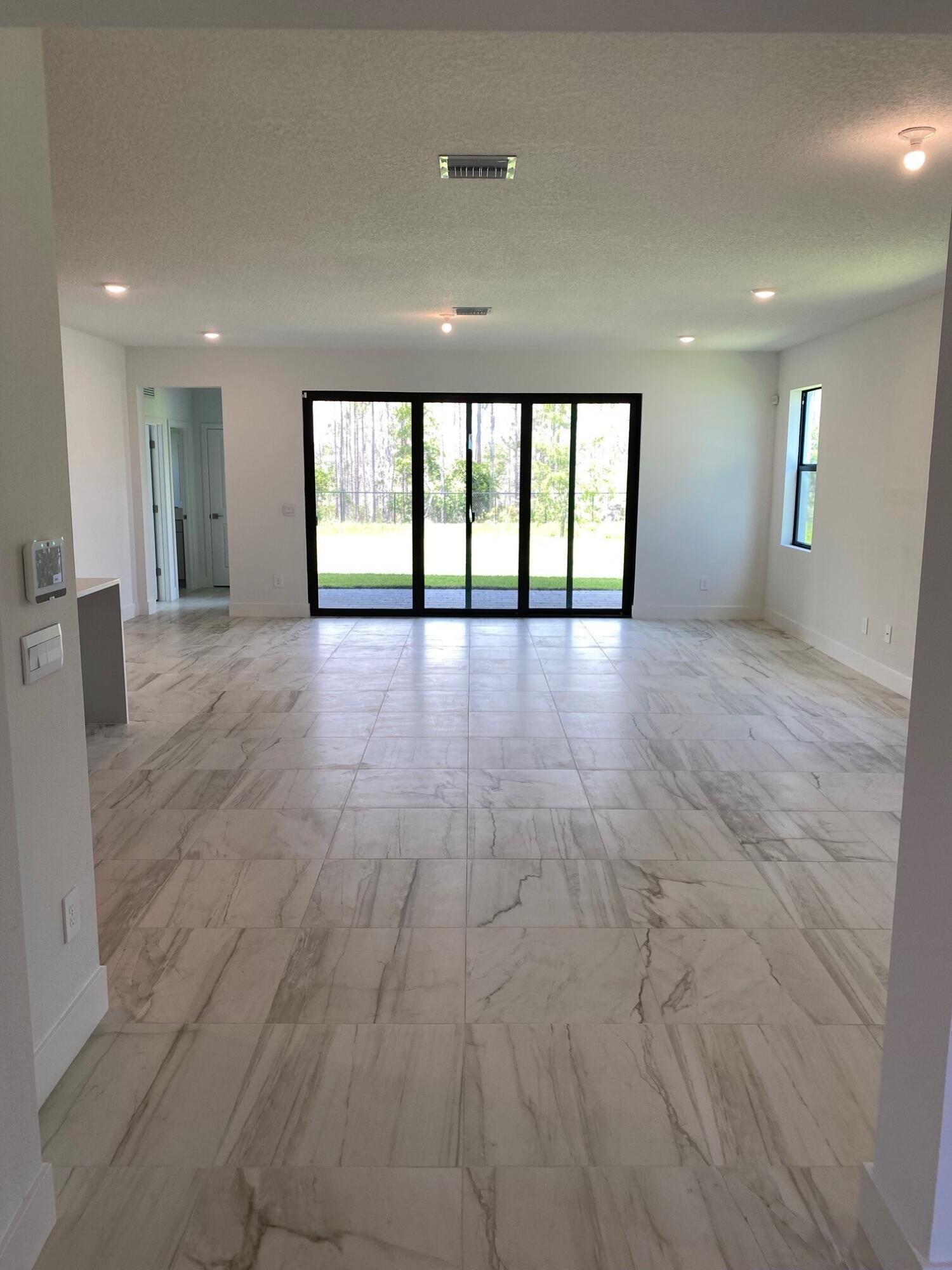 6810 Southeast Park Trace Drive Stuart, FL 34997 - Photo 2 of 21 a view of an empty room with wooden floor and a window