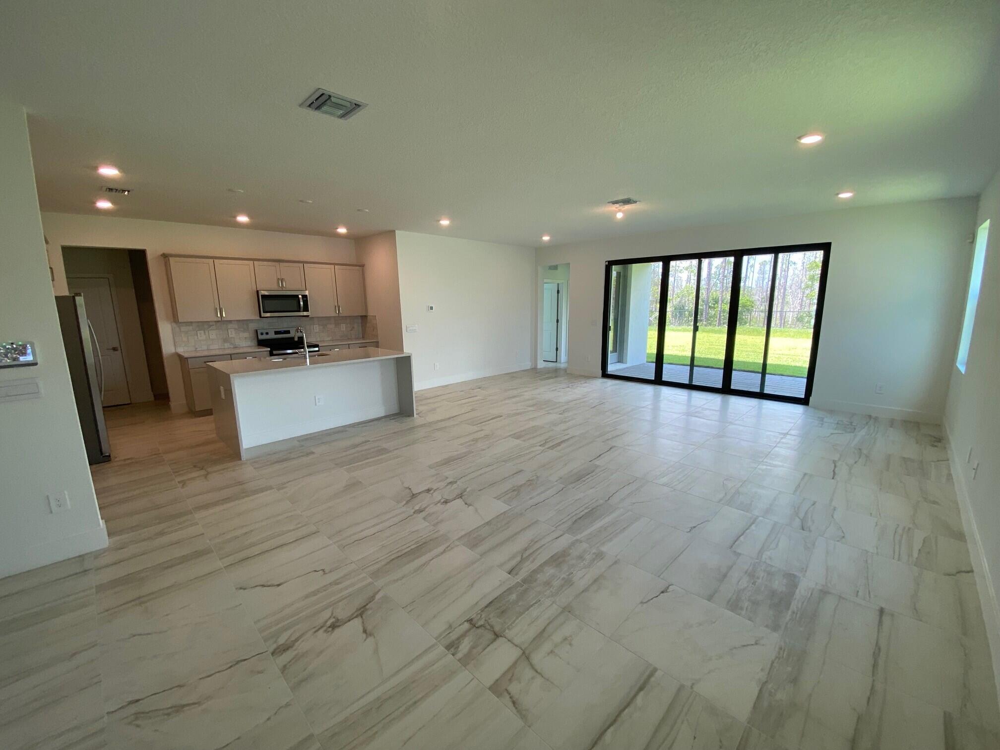 6810 Southeast Park Trace Drive Stuart, FL 34997 - Photo 3 of 21 a view of an empty room with wooden floor and a window