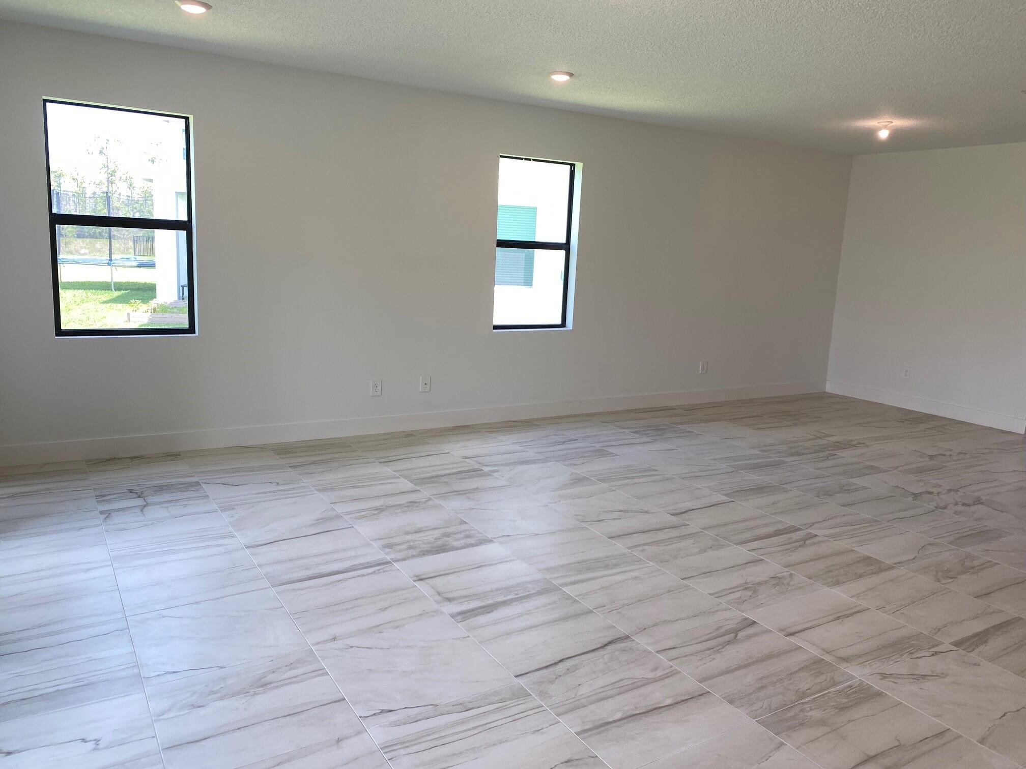 6810 Southeast Park Trace Drive Stuart, FL 34997 - Photo 4 of 21 an empty room with wooden floor and windows