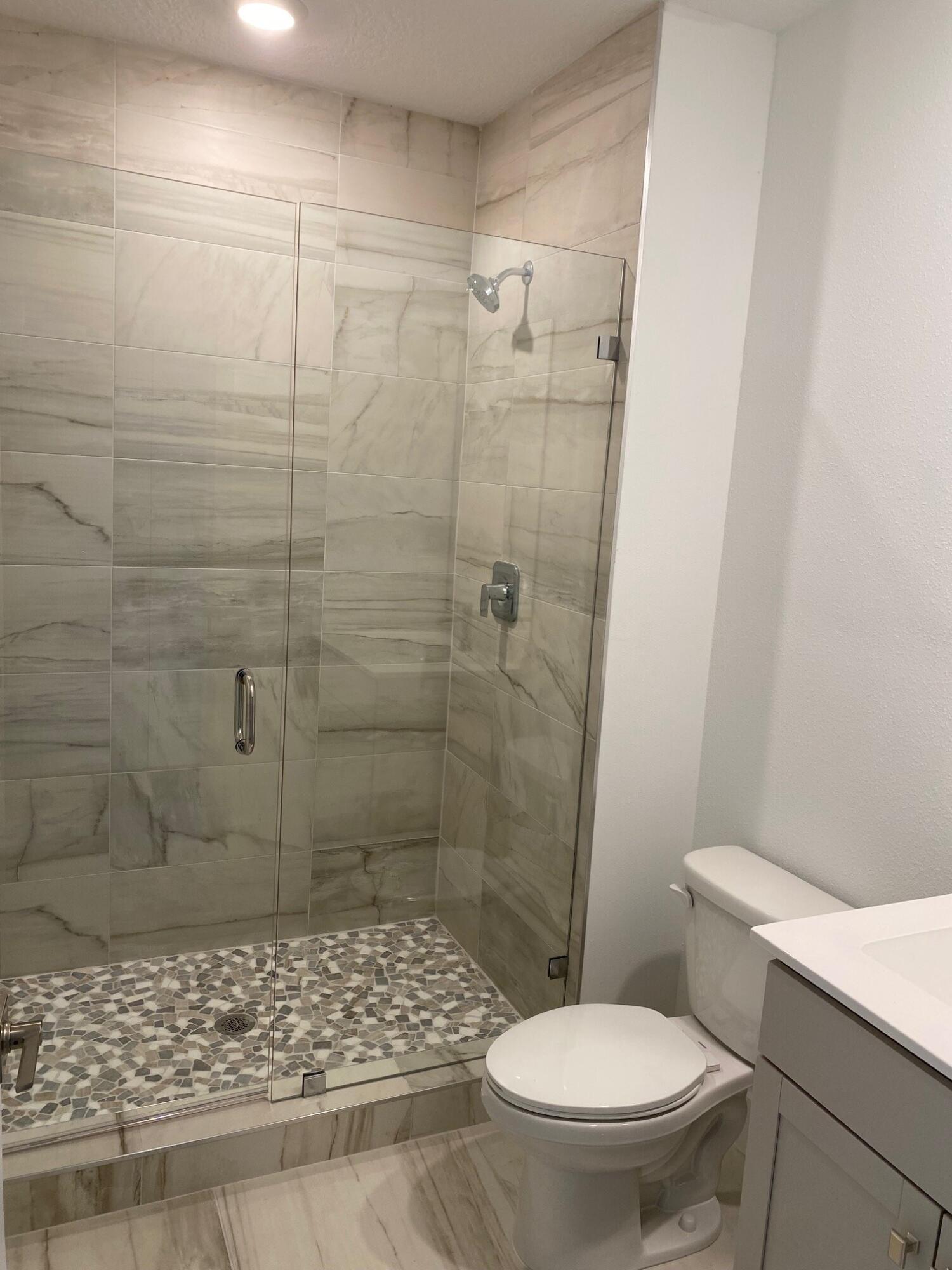 6810 Southeast Park Trace Drive Stuart, FL 34997 - Photo 7 of 21 a bathroom with a toilet and a shower