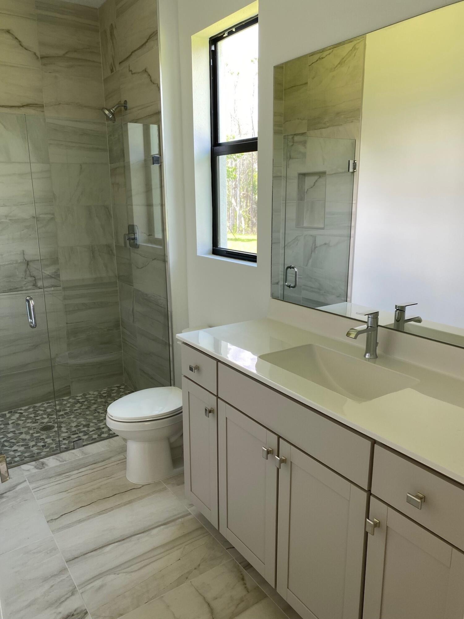 6810 Southeast Park Trace Drive Stuart, FL 34997 - Photo 8 of 21 a bathroom with a sink a toilet and shower