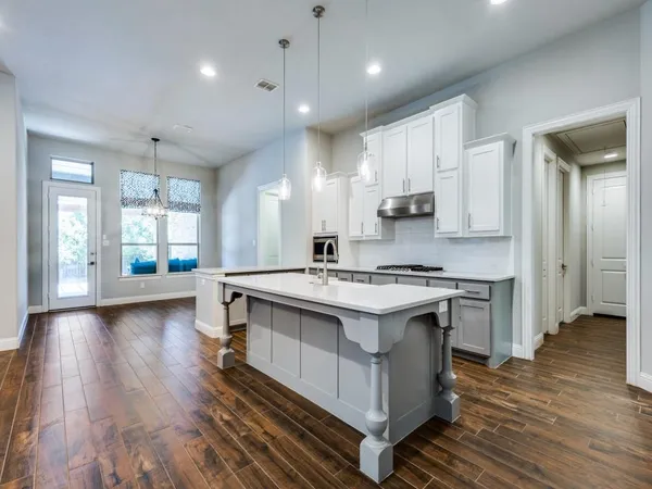 a kitchen with a stove and a wooden floor