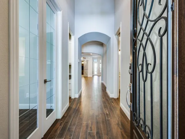 a view of a hallway with wooden floor and stairs