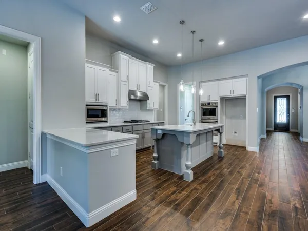 a kitchen with white cabinets and appliances