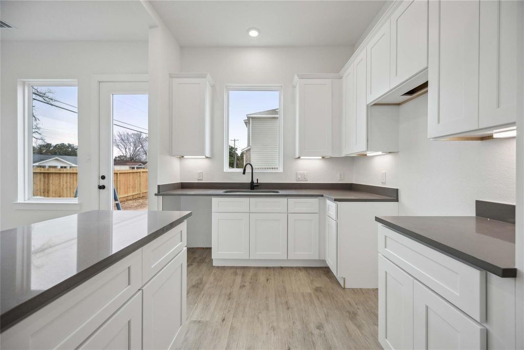 8103 Calhoun Road Houston, TX 77051 - Photo 18 of 29 a kitchen with granite countertop white cabinets and white appliances