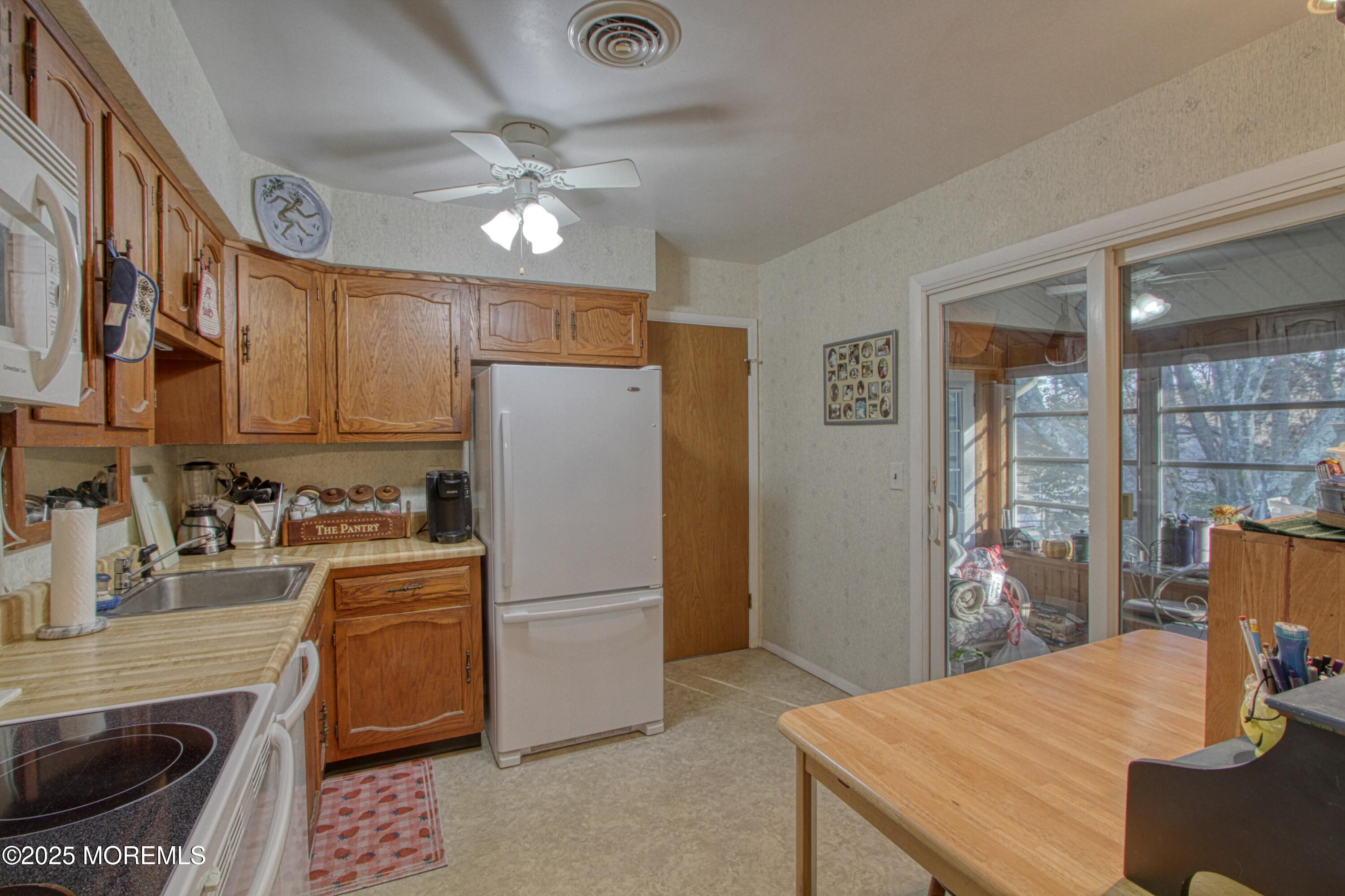 9 Greenleaf Street Whiting, NJ 08759 - Photo 3 of 16 a kitchen with a refrigerator a stove and a dining table with wooden floor