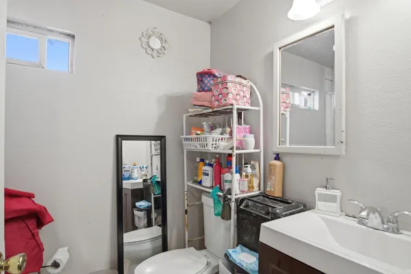 a bathroom with a sink a toilet and a mirror