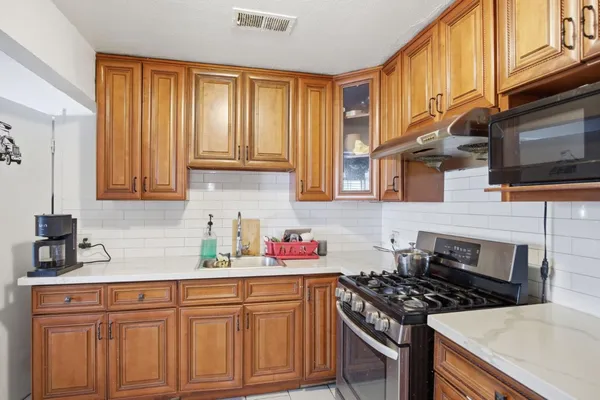 a kitchen with stainless steel appliances granite countertop a stove a sink dishwasher and cabinets with wooden floor