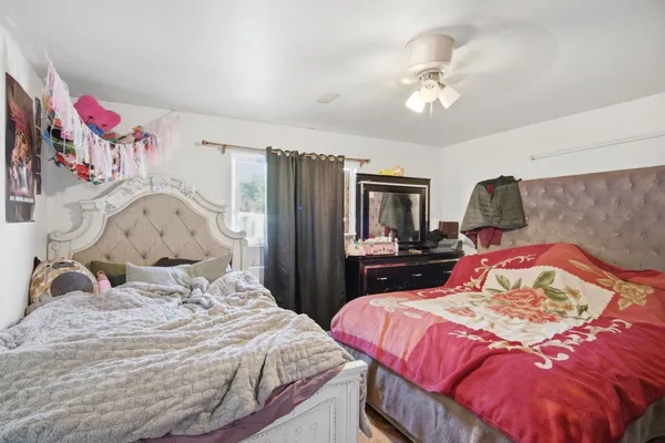 a bedroom with a bed and dresser with mirror