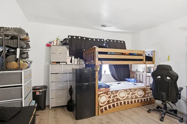 a bedroom with a bed and wooden floor