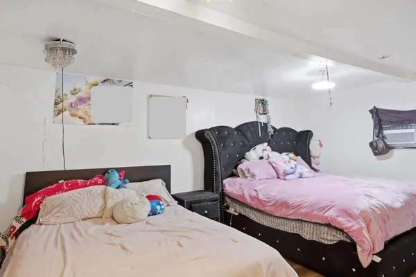 a bedroom with two beds and a chandelier