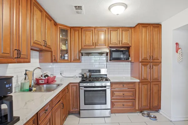 a kitchen with granite countertop wooden cabinets and stainless steel appliances