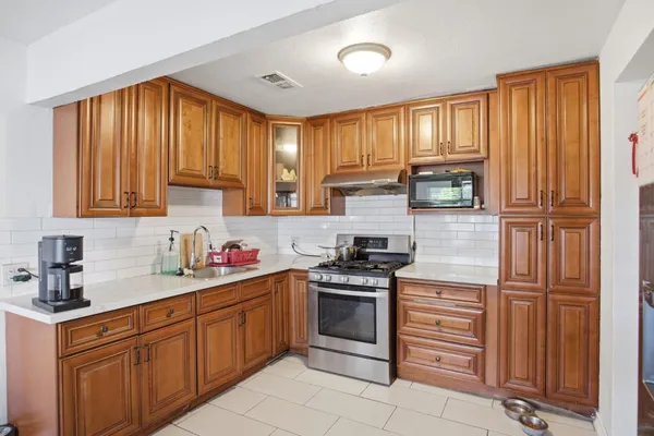 a kitchen with stainless steel appliances granite countertop a stove sink and cabinets