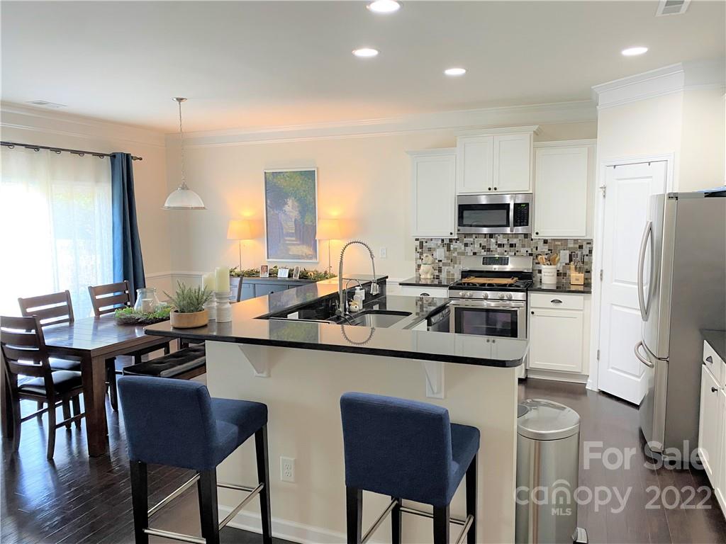 239 Elrosa Road Mooresville, NC 28115 - Photo 3 of 25 a kitchen with a sink a stove a refrigerator and chairs