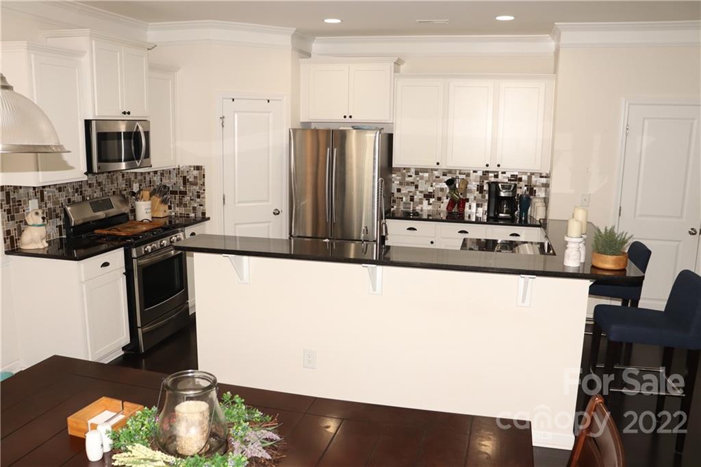 239 Elrosa Road Mooresville, NC 28115 - Photo 5 of 25 a kitchen with stainless steel appliances a refrigerator a sink a stove and white cabinets
