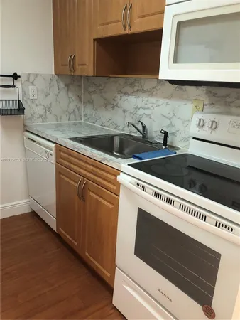a kitchen with granite countertop a sink and a stove top oven