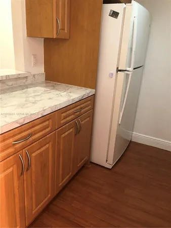 an empty room with wooden floor and cabinet