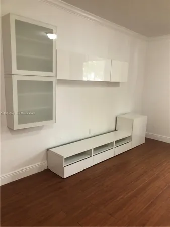 a view of a room with wooden floor and cabinet