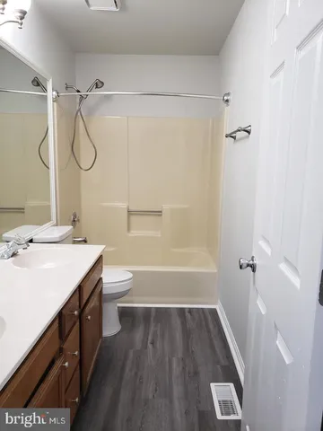 a bathroom with a granite countertop sink a toilet and shower