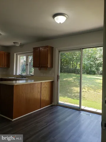 a view of a kitchen with wooden floor and a window
