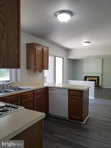 a kitchen with stainless steel appliances granite countertop a stove a sink dishwasher and a microwave oven with wooden floor