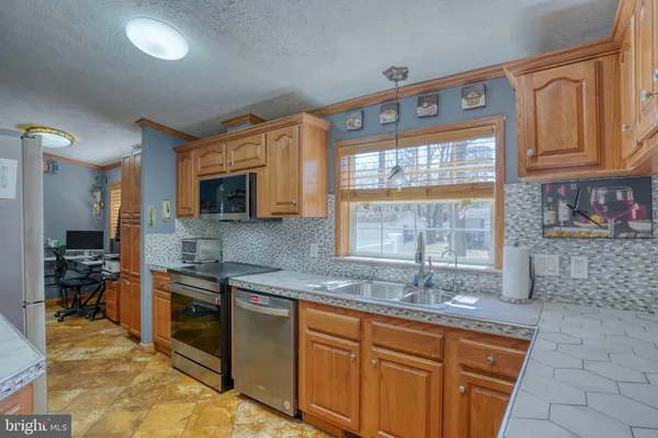 a kitchen with granite countertop a sink a stove and cabinets