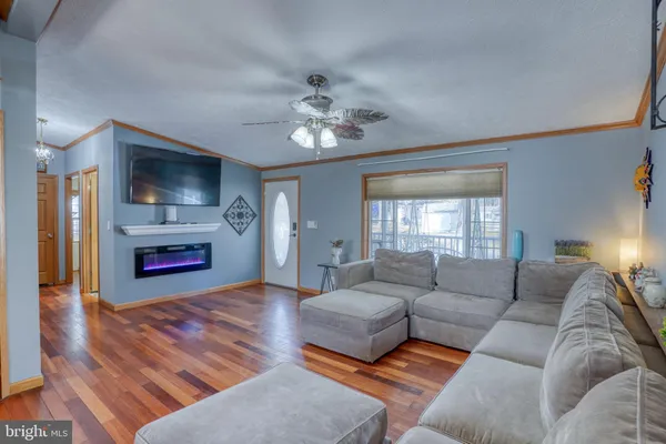 a living room with furniture kitchen view and a chandelier