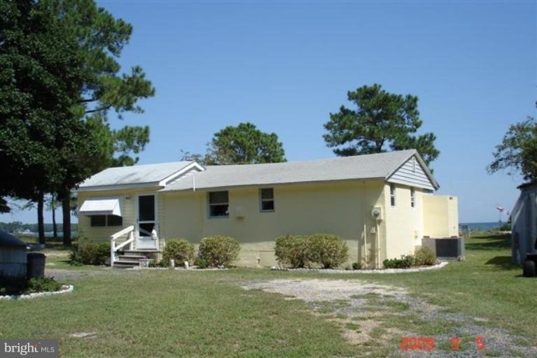 a front view of a house with a garden and trees