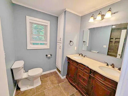 a spacious bathroom with a double vanity sink mirror and toilet