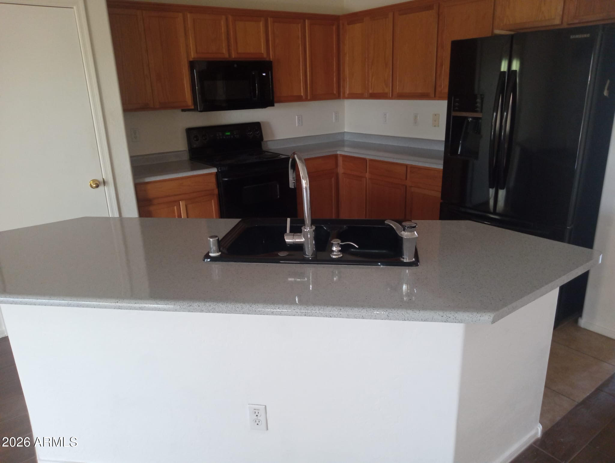 16908 West Northampton Road Surprise, AZ 85374 - Photo 9 of 13 a kitchen with a sink and a refrigerator