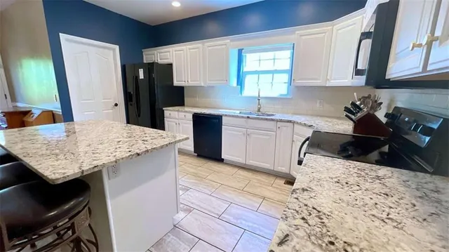 a kitchen with stainless steel appliances granite countertop a refrigerator sink microwave and cabinets