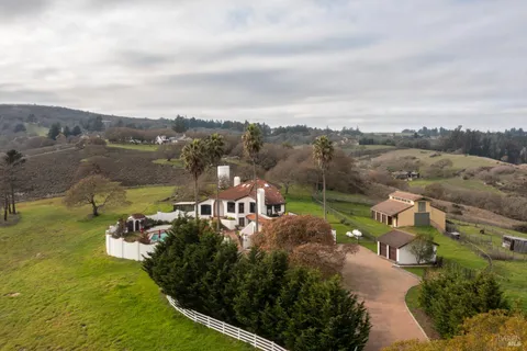 an aerial view of a house with garden space and ocean view