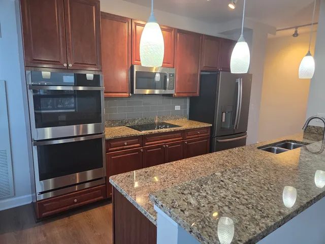 a kitchen with stainless steel appliances granite countertop a sink stove and refrigerator
